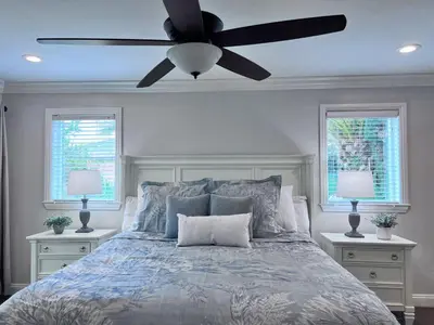 a bedroom with a bed with a ceiling fan at Destination #33 in Orange