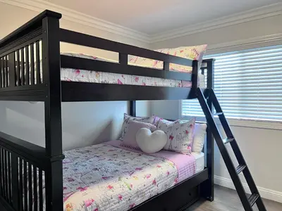 a black bunk bed with a heart pillow in a bedroom at Destination #33 in Orange