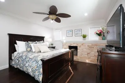 a bedroom with a bed with a fireplace and a ceiling fan at Destination #22 in Anaheim