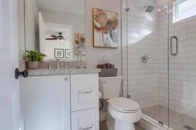 a white bathroom with a toilet and a shower at Destination #46 in Fullerton