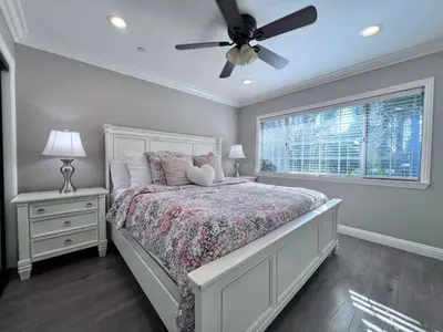 a bedroom with a bed with a ceiling fan and a window at Destination #32 in Anaheim