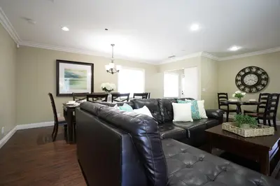 a living room with a leather couch and a table at Classy PoolJac Home: 2 Ensuites 34 Mile2Disney in Anaheim