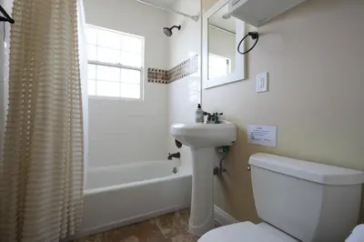 a bathroom with a sink and a toilet and a tub at Classy PoolJac Home: 2 Ensuites 34 Mile2Disney in Anaheim