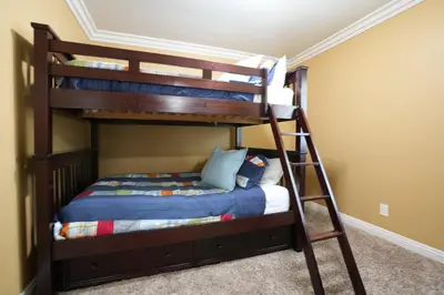 a bedroom with two bunk beds and a ladder at Classy PoolJac Home: 2 Ensuites 34 Mile2Disney in Anaheim