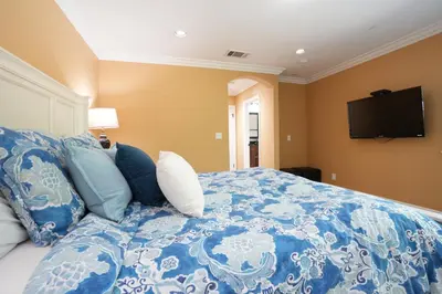 a bedroom with a blue and white bed with a flat screen tv at Classy PoolJac Home: 2 Ensuites 34 Mile2Disney in Anaheim