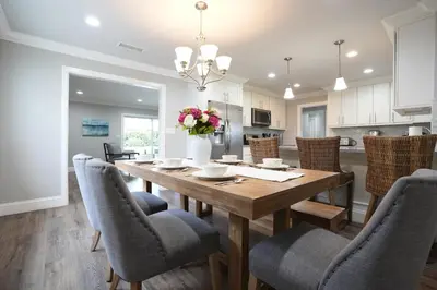 a kitchen and dining room with a wooden table and chairs at Destination #39 in Orange