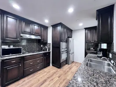 a kitchen with wooden cabinets and a stainless steel refrigerator at Destination #15 in Anaheim