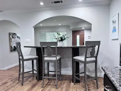 a kitchen with a bar with two stools and a counter at Destination #15 in Anaheim