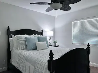 a bedroom with a bed with a ceiling fan at Destination #15 in Anaheim