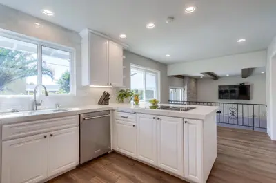 a kitchen with white cabinets and a large window at Destination #44 in Orange