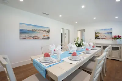 a white dining room with a table and chairs at Destination #45 in Orange