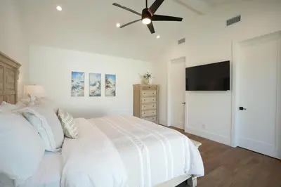 a white bedroom with a bed and a ceiling fan at Destination #45 in Orange