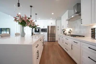 a kitchen with white cabinets and a vase of flowers at Destination #45 in Orange