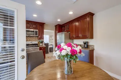 a vase of flowers sitting on a table in a kitchen at Destination #48 in Placentia