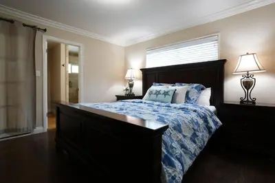 a bedroom with a bed with a blue comforter and a window at Destination #14 in Anaheim