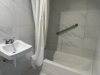 a white bathroom with a sink and a shower at Pomona Inn in Pomona