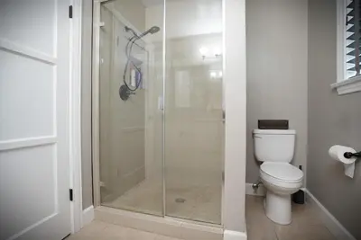 a glass shower in a bathroom with a toilet at Destination #51 in Santa Ana