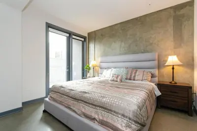 a bedroom with a large bed and a large window at Cozy 3bed Condo with balcony & a rooftop pool in Los Angeles