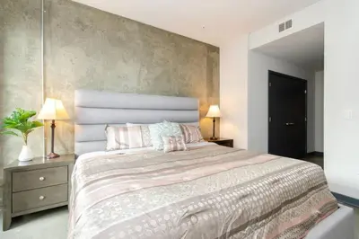 a bedroom with a large bed with pink pillows at Cozy 3bed Condo with balcony & a rooftop pool in Los Angeles