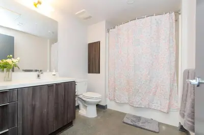 a bathroom with a toilet and a sink and a shower curtain at Cozy 3bed Condo with balcony & a rooftop pool in Los Angeles