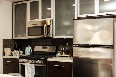 a kitchen with a stainless steel refrigerator and cabinets at Beautiful Studio in West Hollywood in Los Angeles