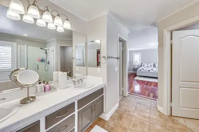 a bathroom with a sink and a mirror and a bedroom at Large Rancho Cucamonga Home 5 Mi to Red Hill Park in Rancho Cucamonga