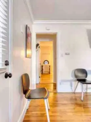 a living room with two chairs and a hallway at Belmont Shore Beach Bungalow, 2 min walk to town! in Long Beach