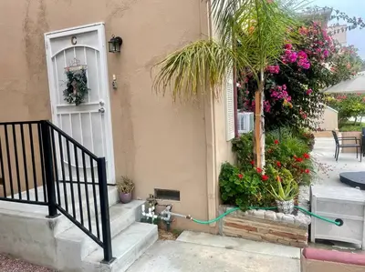 a house with a gate and a door with flowers at Belmont Shore Beach Bungalow, 2 min walk to town! in Long Beach