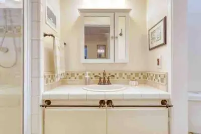 a bathroom with a sink and a mirror and a shower at Belmont Shore Beach Bungalow, 2 min walk to town! in Long Beach