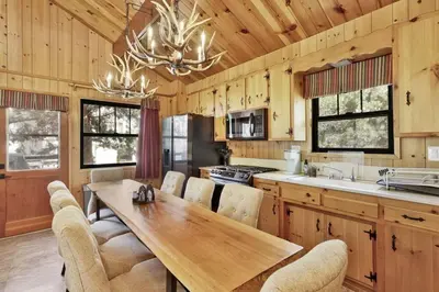 a kitchen with a wooden table and chairs at Bruin Chalet Big Bear~ Cozy Single Level Retreat Cottage~ in Big Bear Lake