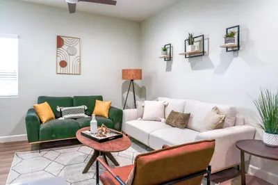 a living room with green and white furniture at Family Getaway Villa to Disneyland! Sleeps up to 22 persons w Game Room, Pool Table & EV Friendly in Midway City