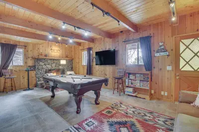 a pool table in a room with wooden walls at Woodsy Lake Arrowhead Cabin with Fire Pit Table in Lake Arrowhead