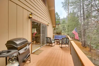 a grill on a porch of a house at Woodsy Lake Arrowhead Cabin with Fire Pit Table in Lake Arrowhead