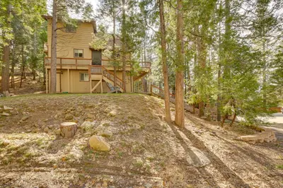 a house in the woods with a yard at Woodsy Lake Arrowhead Cabin with Fire Pit Table in Lake Arrowhead
