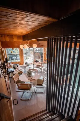 a balcony with a table and chairs on a patio at Lightfoot Cabin Mid-Century Perfect Romantic Getaway Hot Tub Sauna in Running Springs