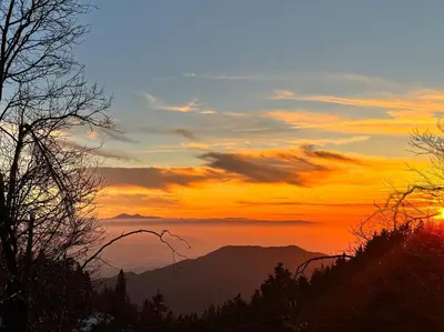 a sunset in the mountains with the sun setting at The Scandia “A-Frame Chalet” Fireplace & Hot tub in Running Springs