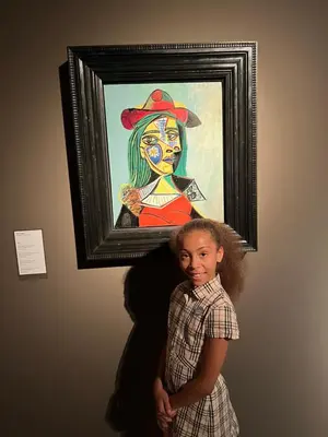 a little girl standing in front of a painting of a woman at Luxury 2 Bedroom Suite Apartment in Koreatown in Los Angeles