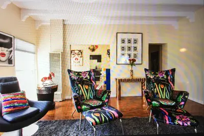 a living room with chairs and a table and a room with paintings at Luxury 2 Bedroom Suite Apartment in Koreatown in Los Angeles
