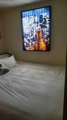 a tv hanging on a wall above a bed at Stylish Apartment in Koreatown! Central Location!! in Los Angeles