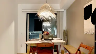 a dining room with a table and chairs and a chandelier at Chic Retreat by Santa Monica in Los Angeles
