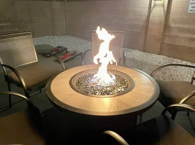 a wooden table with a fire in the middle at New cheerful villa, Pool, Spa, Mini Golf, Game room, Fire pit next to Disneyland in Anaheim