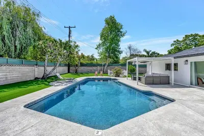 a swimming pool in the backyard of a house at New cheerful villa, Pool, Spa, Mini Golf, Game room, Fire pit next to Disneyland in Anaheim