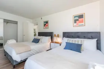 two beds in a bedroom with white and blue at New Renovated Spacious 3 bedroom near DT Alhambra in Alhambra