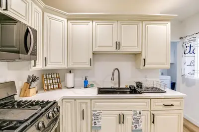a kitchen with white cabinets and a sink at 7 Mi to Dtwn! Modern Retreat in East Los Angeles in East Los Angeles