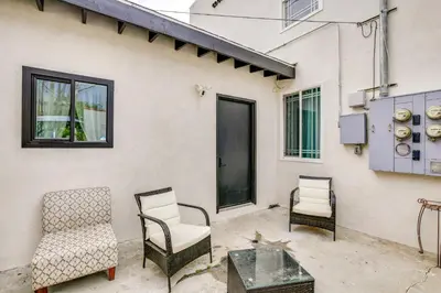 a patio with chairs and a table and a cat at 9 Mi to Dodger Stadium! East LA Studio with Patio in East Los Angeles