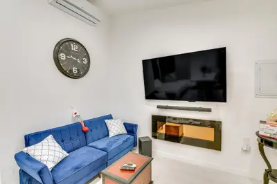 a living room with a blue couch and a clock at 9 Mi to Dodger Stadium! East LA Studio with Patio in East Los Angeles