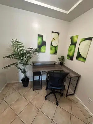 a desk with a plant in a room with paintings at Beverly Hills Midle City 1 br Apt with Parking 202 in Los Angeles