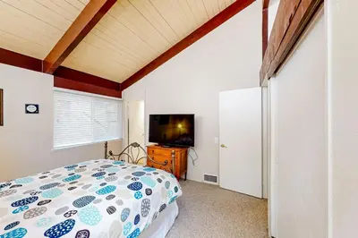 a bedroom with a bed and a flat screen tv at Fernrock Cabin in Twin Peaks