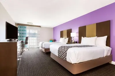a hotel room with two beds and a flat screen tv at La Quinta by Wyndham Pomona in Pomona