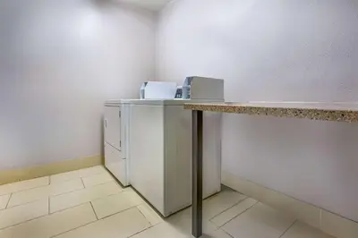 a laundry room with a counter and a refrigerator at La Quinta by Wyndham Pomona in Pomona